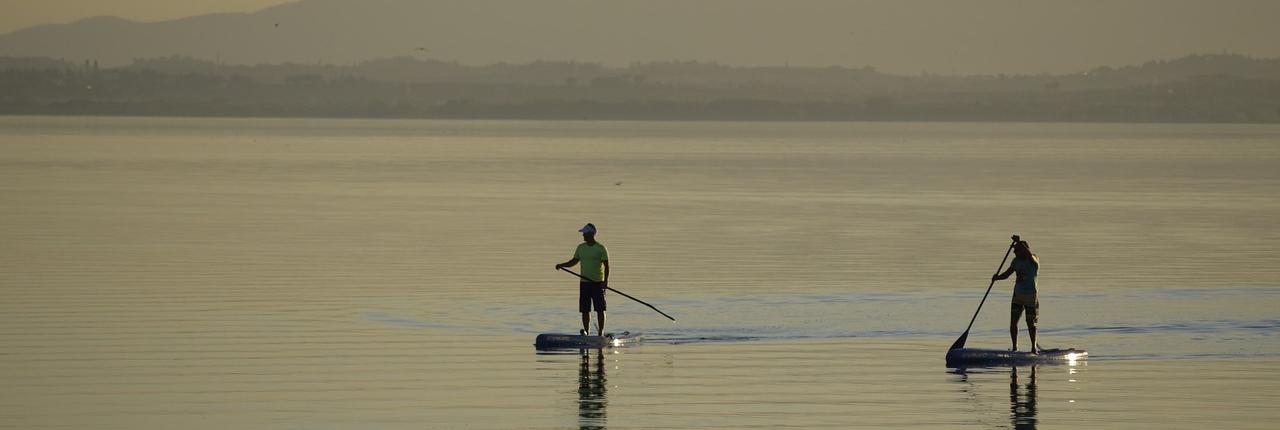 lago trasimeno con ragazzi che fanno sup